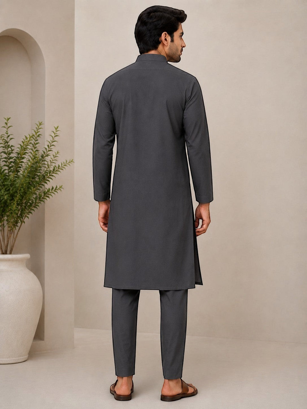 Back view of a man wearing a dark grey Swagzaar cotton blend kurta with a mandarin collar and matching trousers.